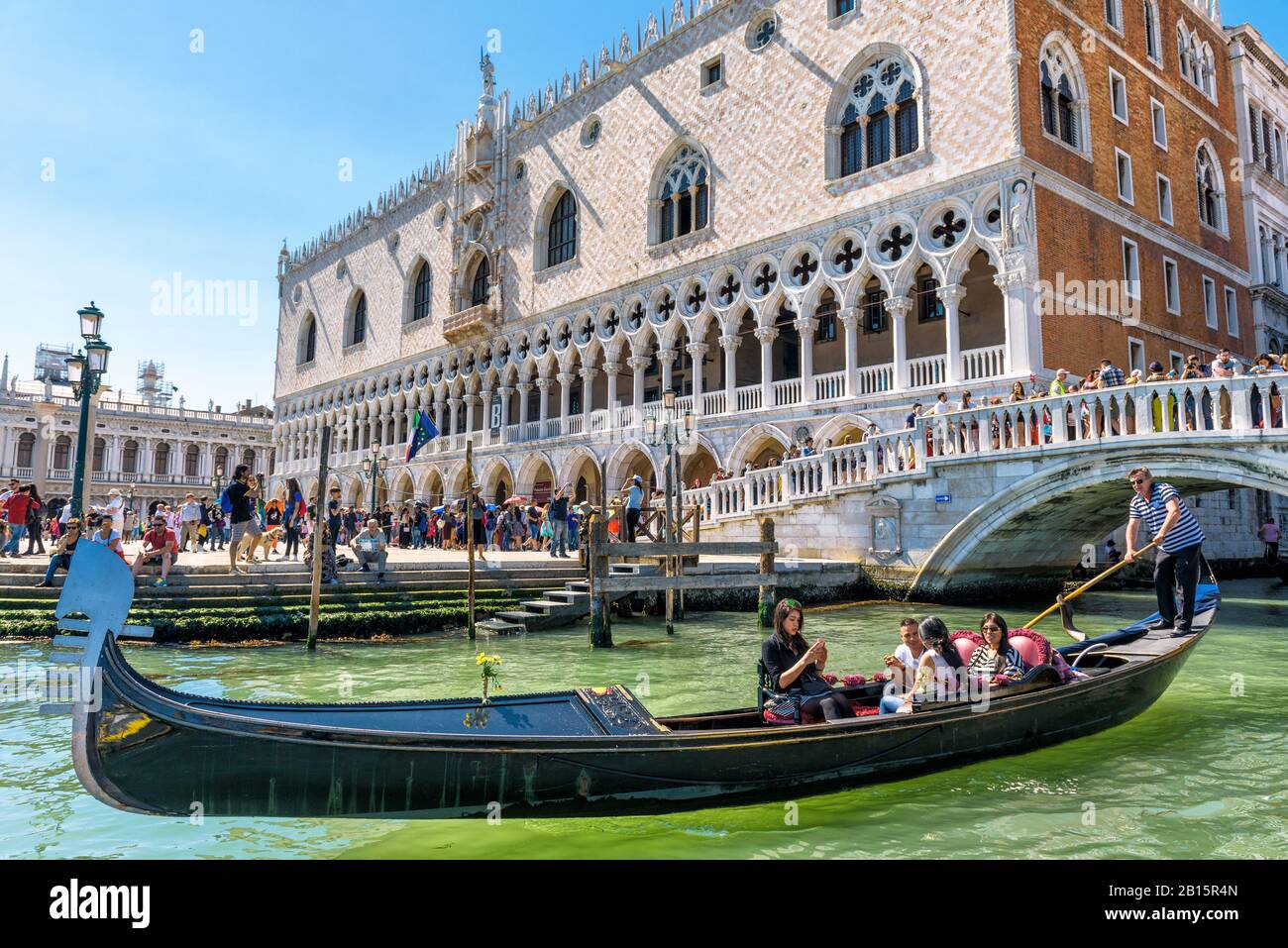 Venice, Italy - May 21, 2017: The gondola with tourists floats near the famous Doge`s Palace (Palazzo Ducale) in the St Mark`s Square. Doge`s Palace i Stock Photo